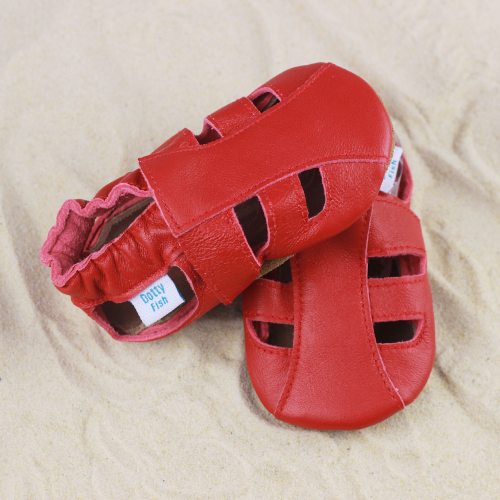 Dotty Fish red leather baby and toddler sandals sitting in the sand