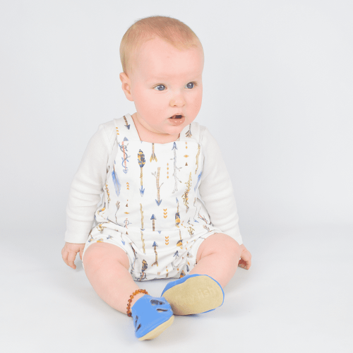 Young baby sitting while wearing soft leather blue sandals from Dotty Fish 