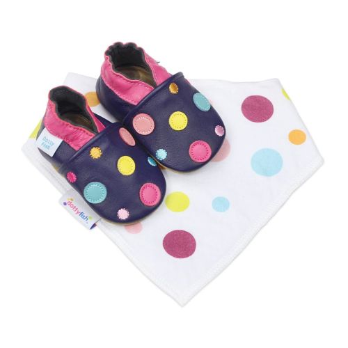 Marineblaue Dotty Fish Schuhe mit weicher Sohle, rosafarbenem Saum und bunten Tupfen, dazu ein passendes weißes Lätzchen mit Tupfenmuster.