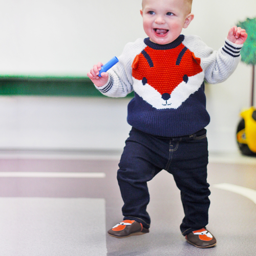 Baby taking first steps while wearing Dotty Fish Freddie Fox soft sole baby shoes 