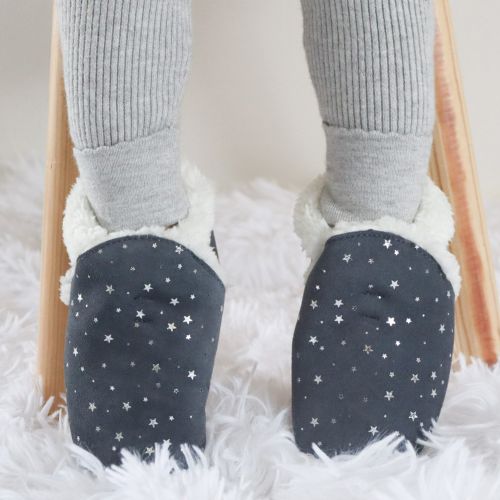 Child wearing warm fleece lined grey suede slippers with silver stars from Dotty Fish 