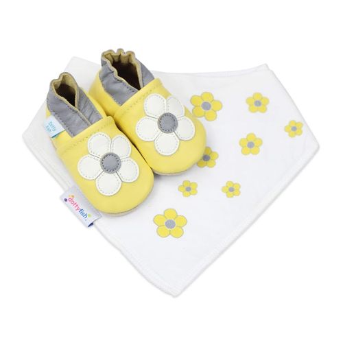 Dotty Fish Geschenkset aus gelben Schuhen mit weißer Blume und passendem gelben Blumentuch-Lätzchen.