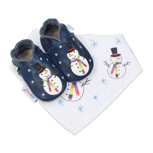 Marineblaue Dotty Fish Schuhe mit weicher Sohle und weißem Schneemann mit schwarzer Mütze und gesticktem Regenbogentuch, dazu ein passendes weißes Lätzchen mit Schneemannmuster.