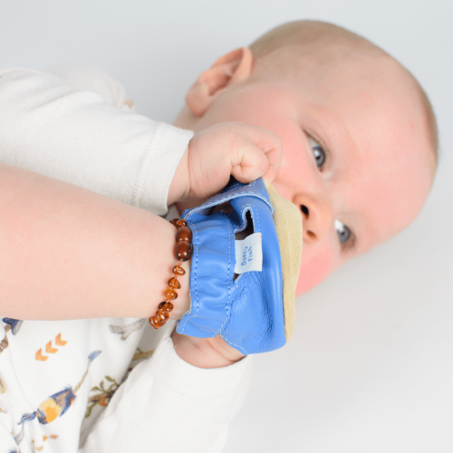 Der kleine Junge trägt blaue Dotty Fish Barfußsandalen aus Leder.