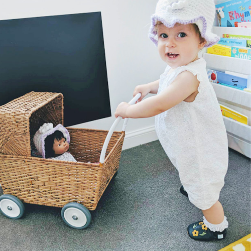 Baby playing while wearing non-slip leather baby shoes in navy with honey blossom design