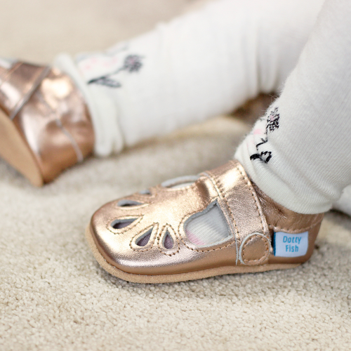 Baby wearing Dotty Fish classic Rose Gold T-bar style baby shoes