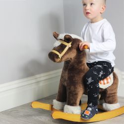 Kleinkind mit navyfarbenen Dotty Fish Kinderschuhen mit silbernem und orangefarbenem Roboterdesign auf einem Schaukelpferd sitzend.