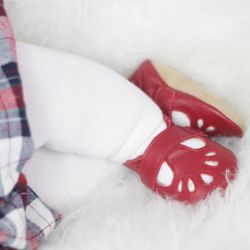 Little baby girl wearing red T-bar baby shoes by Dotty Fish