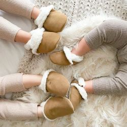 Children wearing fleece lined suede slippers from Dotty Fish while lying down