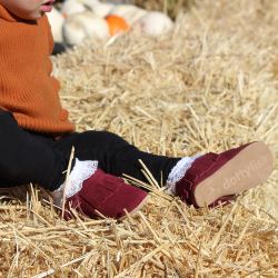 Baby wearing berry red baby moccasins from Dotty Fish 
