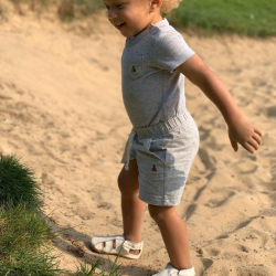 Toddler playing in the sand while wearing cream leather sandals with soft soles form Dotty Fish 