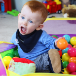 Teething baby wearing absorbent cotton bandana bib from Dotty Fish