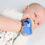 Baby chewing Dotty Fish soft sole sandals which are made from baby safe leather