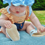 Baby girl wearing Dotty Fish soft sole baby sandals while outside