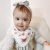 Baby Mädchen trägt Dotty Fish weißes Baumwolle-Bandana-Lätzchen mit rosa Schmetterlingsmuster.