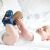 Baby trägt marineblaue Baumwollstiefel mit Dinosaurier-Design.