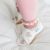 Baby trägt weiße Leder Dotty Fish erste walker barfuß Schuhe mit rosa Herzen.