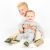 Ein Baby und ein Kleinkind sitzen zusammen und tragen braune Dotty Fish Dinosaurierschuhe.