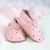 Rosa Babyschuhe mit ausgeschnittenen Herzen.